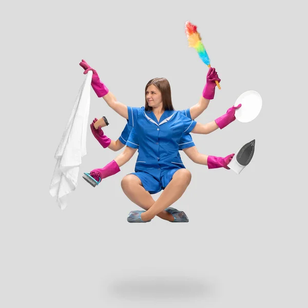 Femme femme femme de ménage en gants roses et uniforme bleu multitâche comme shiva isolé sur fond gris. Les émotions humaines. — Photo