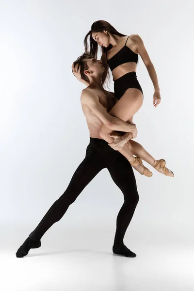 Jóvenes y elegantes bailarines de ballet en un estilo negro minimalista aislados sobre fondo blanco de estudio — Foto de Stock