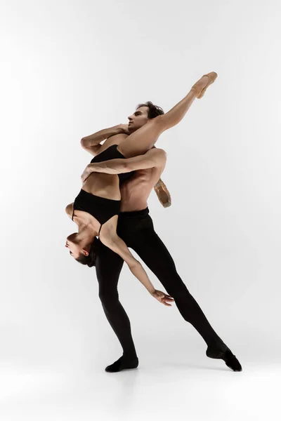 Jóvenes y elegantes bailarines de ballet en un estilo negro minimalista aislados sobre fondo blanco de estudio —  Fotos de Stock