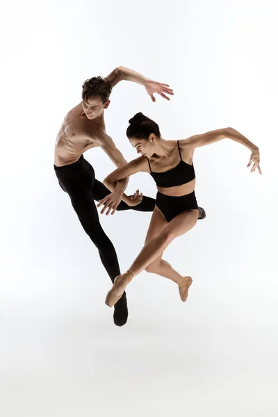 Jóvenes y elegantes bailarines de ballet en un estilo negro minimalista aislados sobre fondo blanco de estudio — Foto de Stock