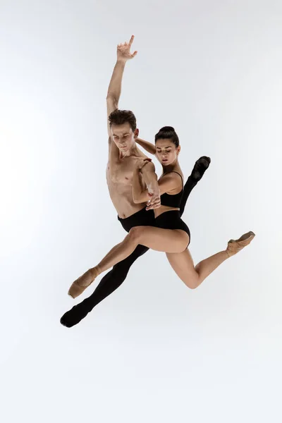 Dois dançarinos de balé graciosos homem e mulher em estilo preto mínimo dançando isolado no fundo do estúdio branco — Fotografia de Stock