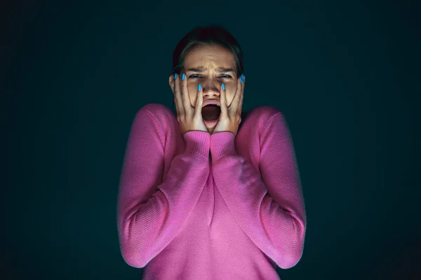 Närbild porträtt av ung galen rädd och chockad kvinna isolerad på mörk bakgrund — Stockfoto