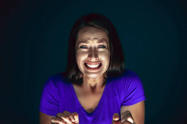 Close-up portret van jong gek bang en geschokt vrouw geïsoleerd op donkere achtergrond — Stockfoto