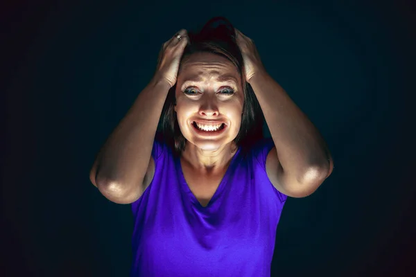 Gros plan portrait de jeune folle effrayée et choquée femme isolée sur fond sombre — Photo