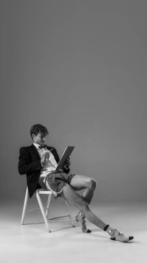 Genç, modaya uygun, ceketli ve çoraplı bir adam evde çalışıyor. Koronavirüs salgınının izolasyon nedeni sırasında moda.