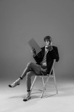 Genç, modaya uygun, ceketli ve çoraplı bir adam evde çalışıyor. Koronavirüs salgınının izolasyon nedeni sırasında moda.