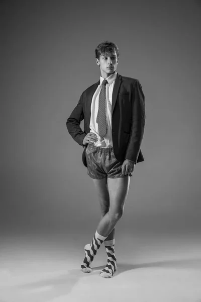 Mladý módní, stylový muž v bundě a ponožkách, pracující z domova. Móda během izolace způsobující pandemii koronaviru — Stock fotografie