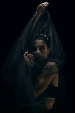 Siyah stüdyo arka planında izole edilmiş zarif bir bayan balerin. Zarafet, sanatçı, hareket, aksiyon ve hareket konsepti.