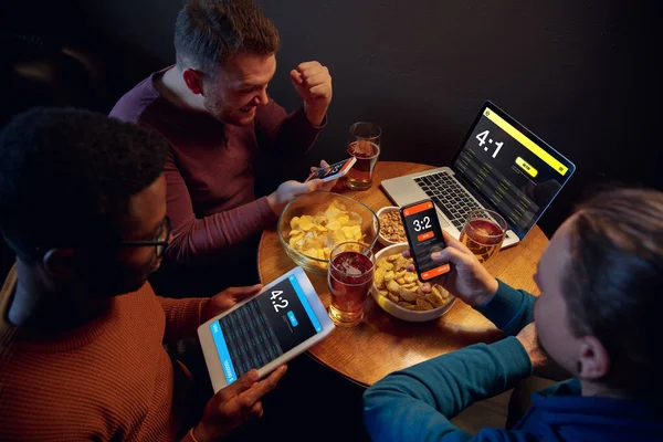 Aufgeregte Fans mit mobiler App für Wetten und Tore auf ihren Geräten. Glücksspiel, Emotionen — Stockfoto