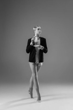 Ceket ve çorap giyen şık, genç bir bayan evde çalışıyor. Koronavirüs salgınının izolasyon nedeni sırasında moda.