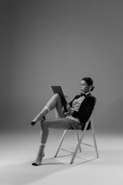 Ceket ve çorap giyen şık, genç bir bayan evde çalışıyor. Koronavirüs salgınının izolasyon nedeni sırasında moda.