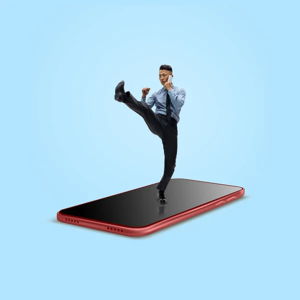 Trabalhador de escritório, homem de negócios lutando na superfície da tela de smartphones isolados em segundo plano — Fotografia de Stock