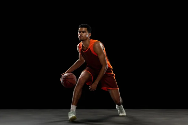 Young african basketball player training on black studio background. — ストック写真