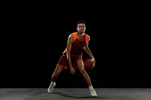 Entrenamiento de jugador de baloncesto africano joven en fondo de estudio negro. —  Fotos de Stock