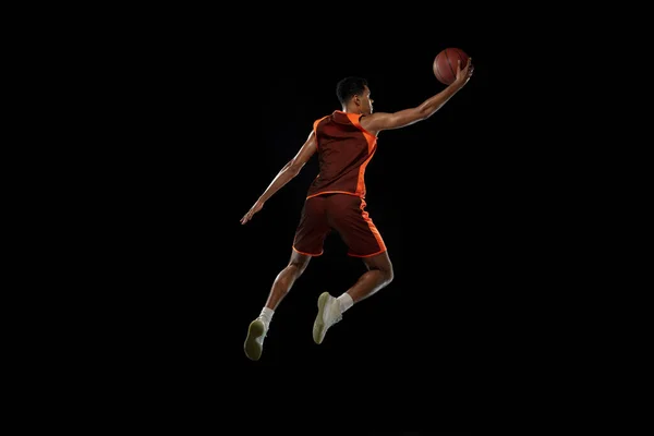 Entrenamiento de jugador de baloncesto africano joven en fondo de estudio negro. — Foto de Stock