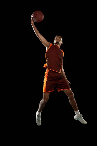 Entrenamiento de jugador de baloncesto africano joven en fondo de estudio negro. — Foto de Stock