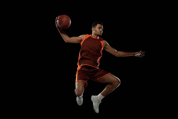 Entrenamiento de jugador de baloncesto africano joven en fondo de estudio negro. —  Fotos de Stock