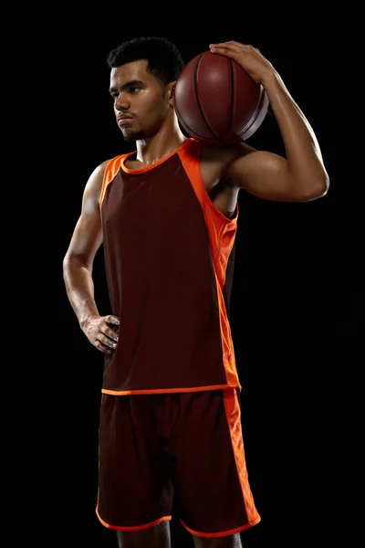 Junge afrikanische Basketballspielerin beim Training auf schwarzem Studiohintergrund. — Stockfoto