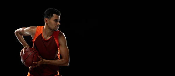 Entrenamiento de jugador de baloncesto africano joven en fondo de estudio negro. —  Fotos de Stock