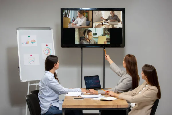 Wanita muda berbicara, bekerja selama konferensi video dengan rekan-rekan di kantor atau ruang tamu — Stok Foto