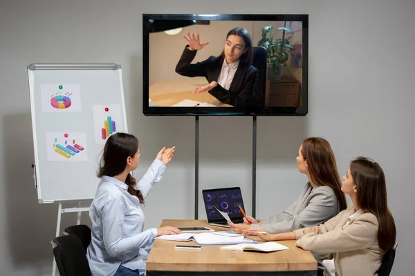 Wanita muda berbicara, bekerja selama konferensi video dengan rekan-rekan di kantor atau ruang tamu — Stok Foto