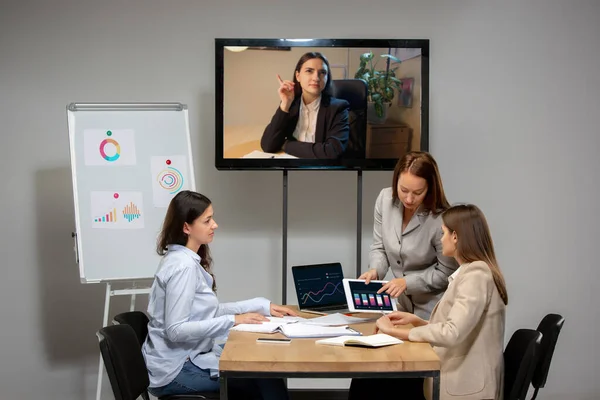 Jeunes femmes parlant, travaillant pendant la vidéoconférence avec des collègues au bureau ou dans le salon — Photo