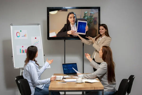 Wanita muda berbicara, bekerja selama konferensi video dengan rekan-rekan di kantor atau ruang tamu — Stok Foto