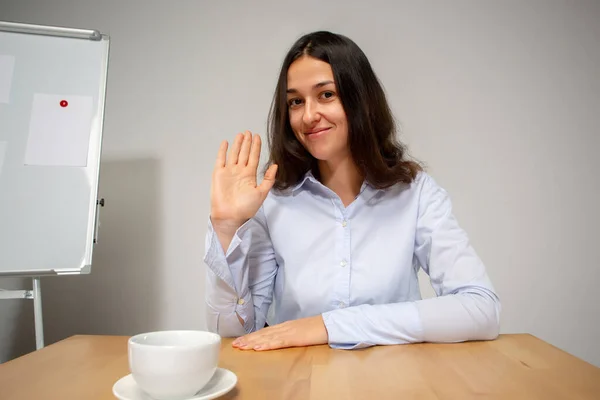 Молода жінка розмовляє, працює під час відеоконференції з колегами в домашньому офісі — стокове фото