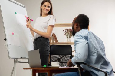 Evde İngilizce kursları. Gülümseyen adam oturma odasında öğrencilere ders veriyor.