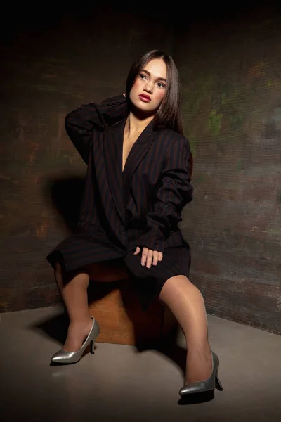 Modelo inclusivo femenino caucásico posando sobre fondo de estudio oscuro en traje negro clásico — Foto de Stock