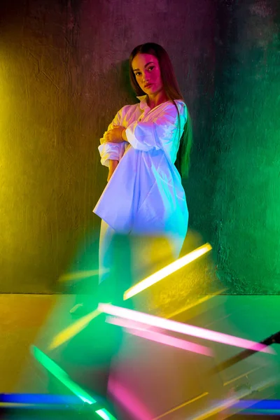 Kaukasische Models posieren im Neonlicht auf Studiohintergrund — Stockfoto