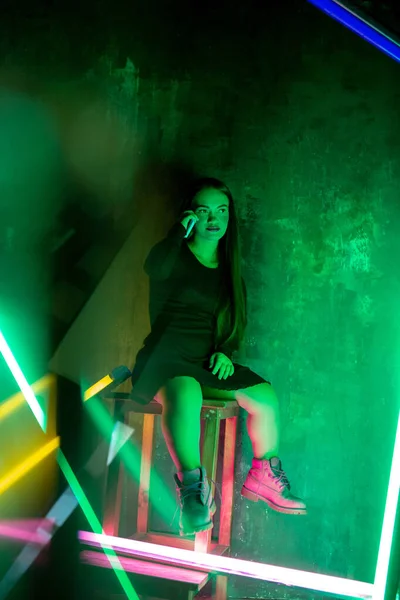 Кавказская женская инклюзивная модель, позирующая на фоне студии в неоновом свете — стоковое фото