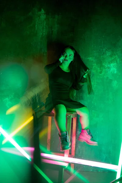 Kaukasiska kvinnliga inkluderande modell poserar på studio bakgrund i neon ljus — Stockfoto