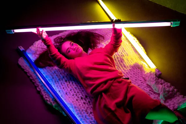Caucasian female inclusive model posing on studio background in neon light — Stock Photo, Image