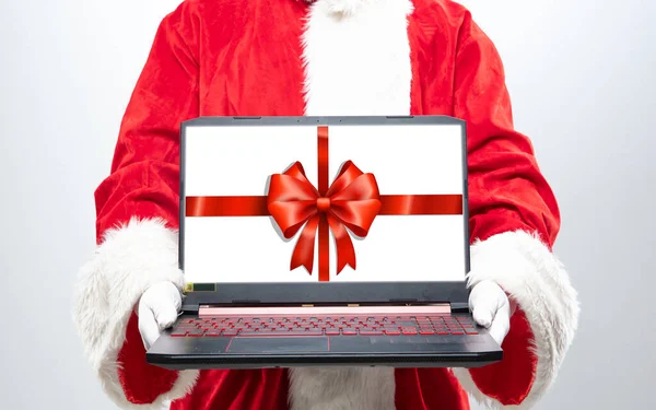 Cerca de las manos de Santa Claus dispositivo de retención con decoración de regalo en la pantalla — Foto de Stock