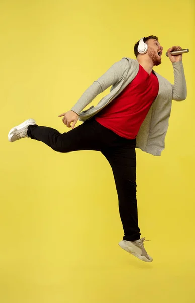 Retrato de comprimento total de jovem bem-sucedido salto alto homem gesto isolado no fundo do estúdio amarelo — Fotografia de Stock