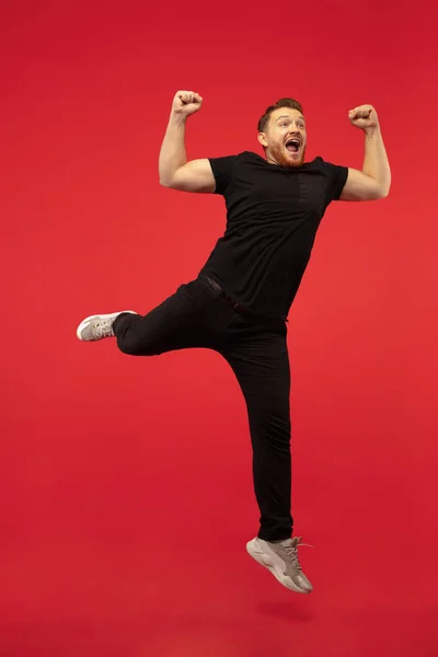 Retrato de comprimento total de jovem bem-sucedido salto alto homem gesto isolado no fundo do estúdio vermelho — Fotografia de Stock