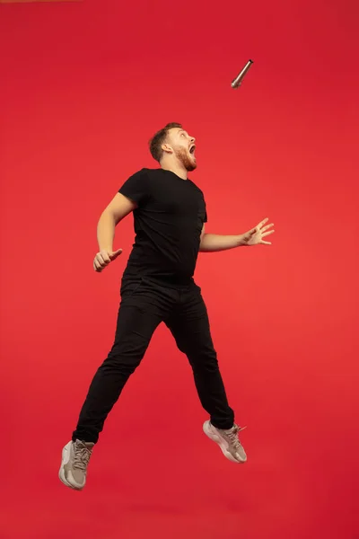 Retrato de comprimento total de jovem bem-sucedido salto alto homem gesto isolado no fundo do estúdio vermelho — Fotografia de Stock