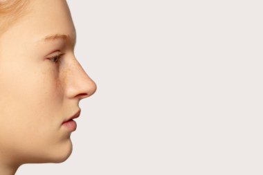 Stüdyo arka planında izole edilmiş güzel kızıl saçlı beyaz kız portresi. Güzellik, moda, cilt bakımı, kozmetik konsepti. Ayrıntılar.