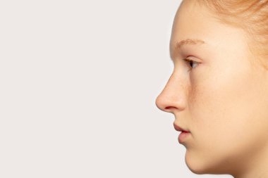 Stüdyo arka planında izole edilmiş güzel kızıl saçlı beyaz kız portresi. Güzellik, moda, cilt bakımı, kozmetik konsepti. Ayrıntılar.