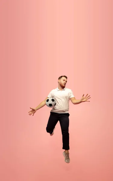 Täyspitkä muotokuva nuorten onnistuneen korkea hyppääminen mies eleiden eristetty vaaleanpunainen studio tausta — kuvapankkivalokuva
