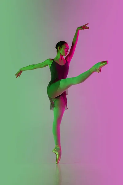 Mladý a půvabný baletní tanečník izolovaný na růžovo-zeleném pozadí v neonovém světle. Art in motion — Stock fotografie