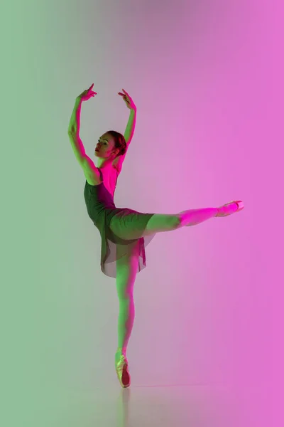 Jeune et gracieuse danseuse de ballet isolée sur fond de studio dégradé rose-vert au néon. L'art en mouvement — Photo