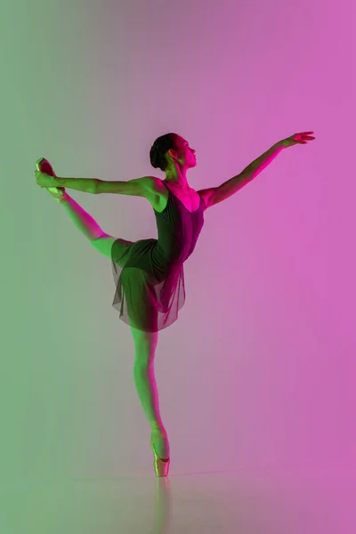 Jeune et gracieuse danseuse de ballet isolée sur fond de studio dégradé rose-vert au néon. L'art en mouvement — Photo