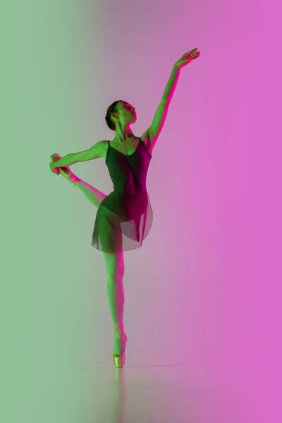 Mladý a půvabný baletní tanečník izolovaný na růžovo-zeleném pozadí v neonovém světle. Art in motion — Stock fotografie