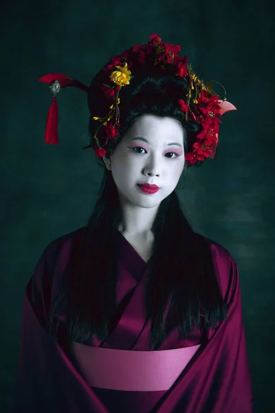 Joven mujer japonesa como geisha sobre fondo verde oscuro. Estilo retro, comparación de conceptos de eras. —  Fotos de Stock