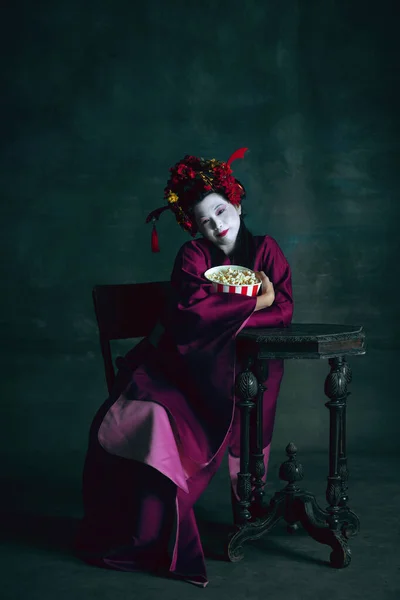 Joven mujer japonesa como geisha sobre fondo verde oscuro. Estilo retro, comparación de conceptos de eras. —  Fotos de Stock