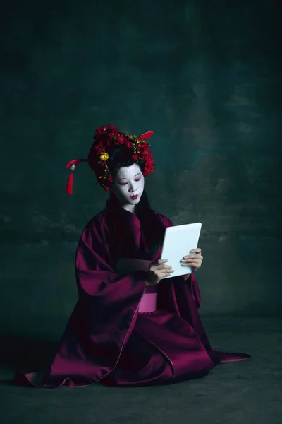 Joven mujer japonesa como geisha sobre fondo verde oscuro. Estilo retro, comparación de conceptos de eras. — Foto de Stock