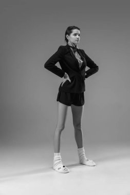 Ceket ve çorap giyen şık, genç bir bayan evde çalışıyor. Koronavirüs salgınının izolasyon nedeni sırasında moda.