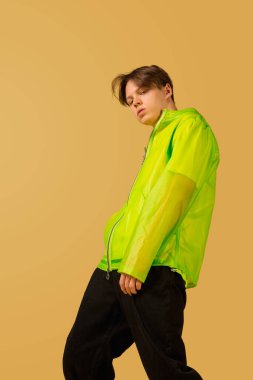 Sarı arka planda yalnız dans eden eski moda genç adam.